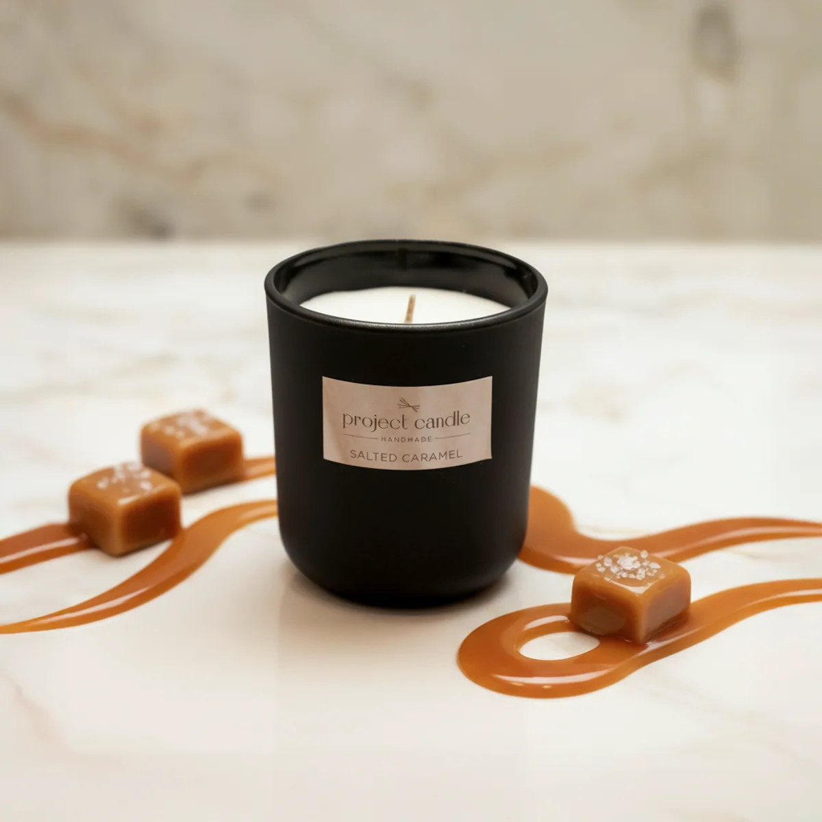 Χειροποίητο αρωματικό κερί Salted Caramel σε μαύρο γυάλινο δοχείο, με γλυκό άρωμα καραμέλας.