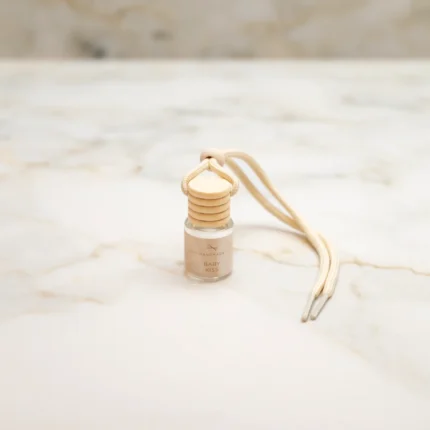 Κρεμαστό αρωματικό αυτοκινήτου Baby Kiss 6ml σε γυάλινο μπουκαλάκι, με αίσθηση καθαριότητας και φρεσκάδας.